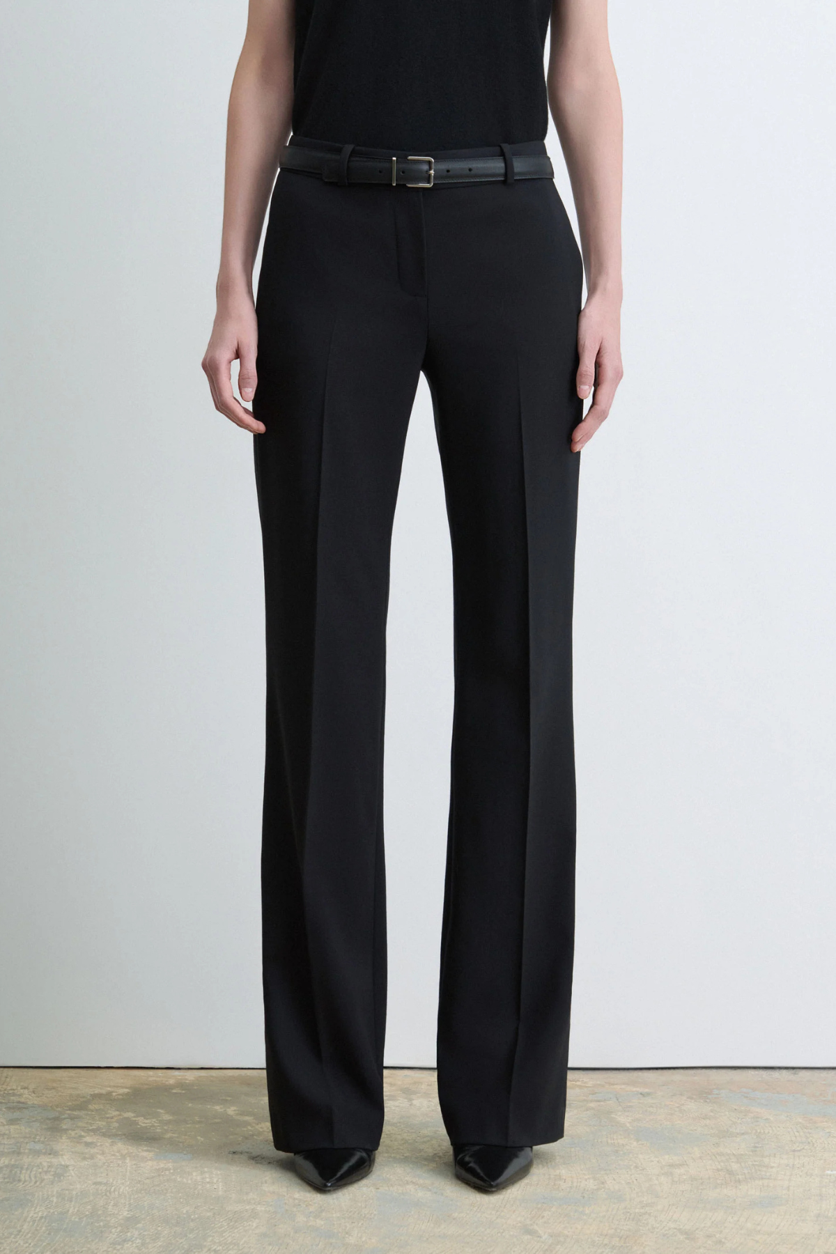 Judith & Charles Ilan B Pant in black stretch virgin wool, featuring a low-rise waist, pressed front creases, slash pockets and a flared leg.