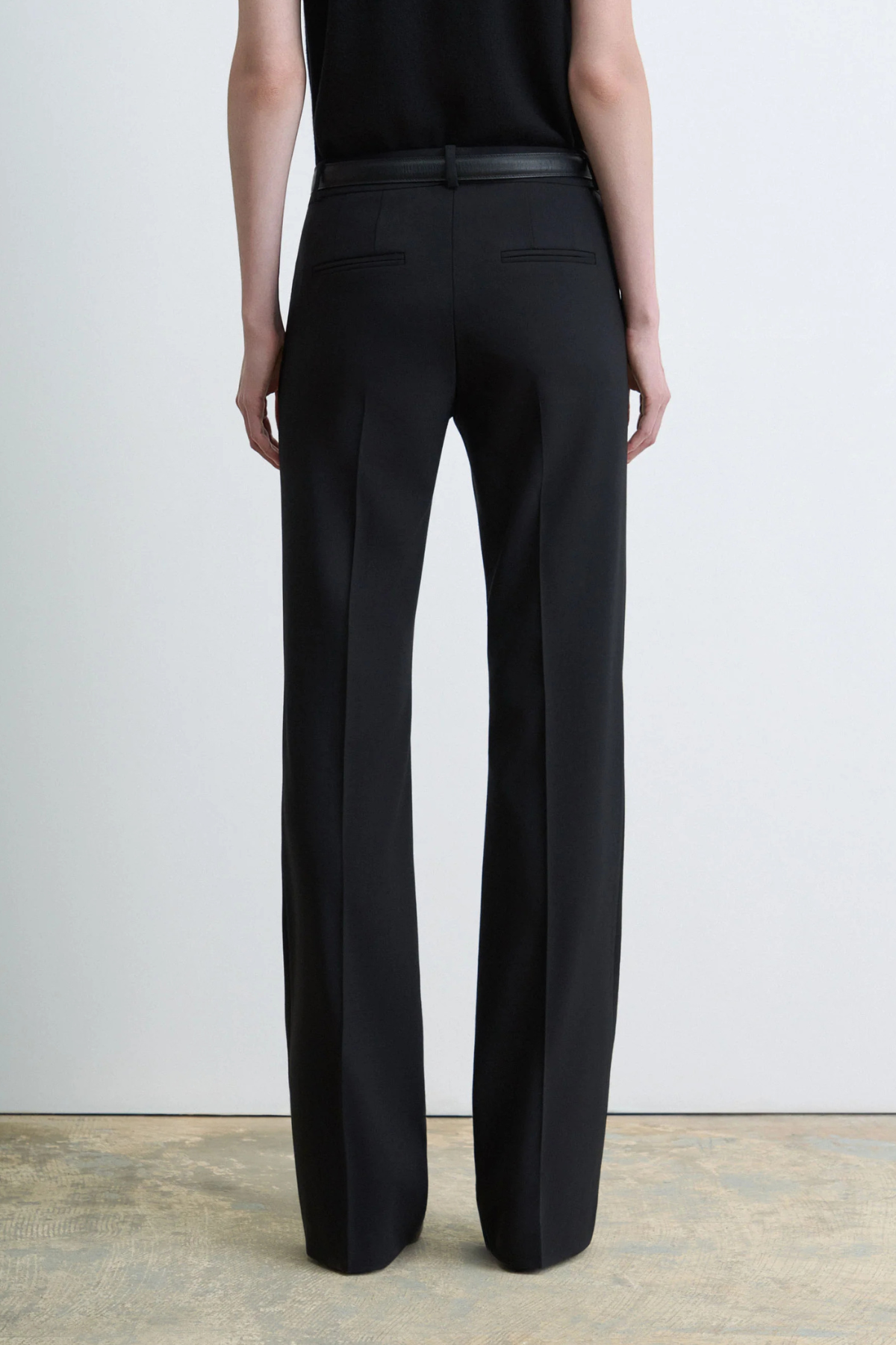 Judith & Charles Ilan B Pant in black stretch virgin wool, featuring a low-rise waist, pressed front creases, slash pockets and a flared leg.