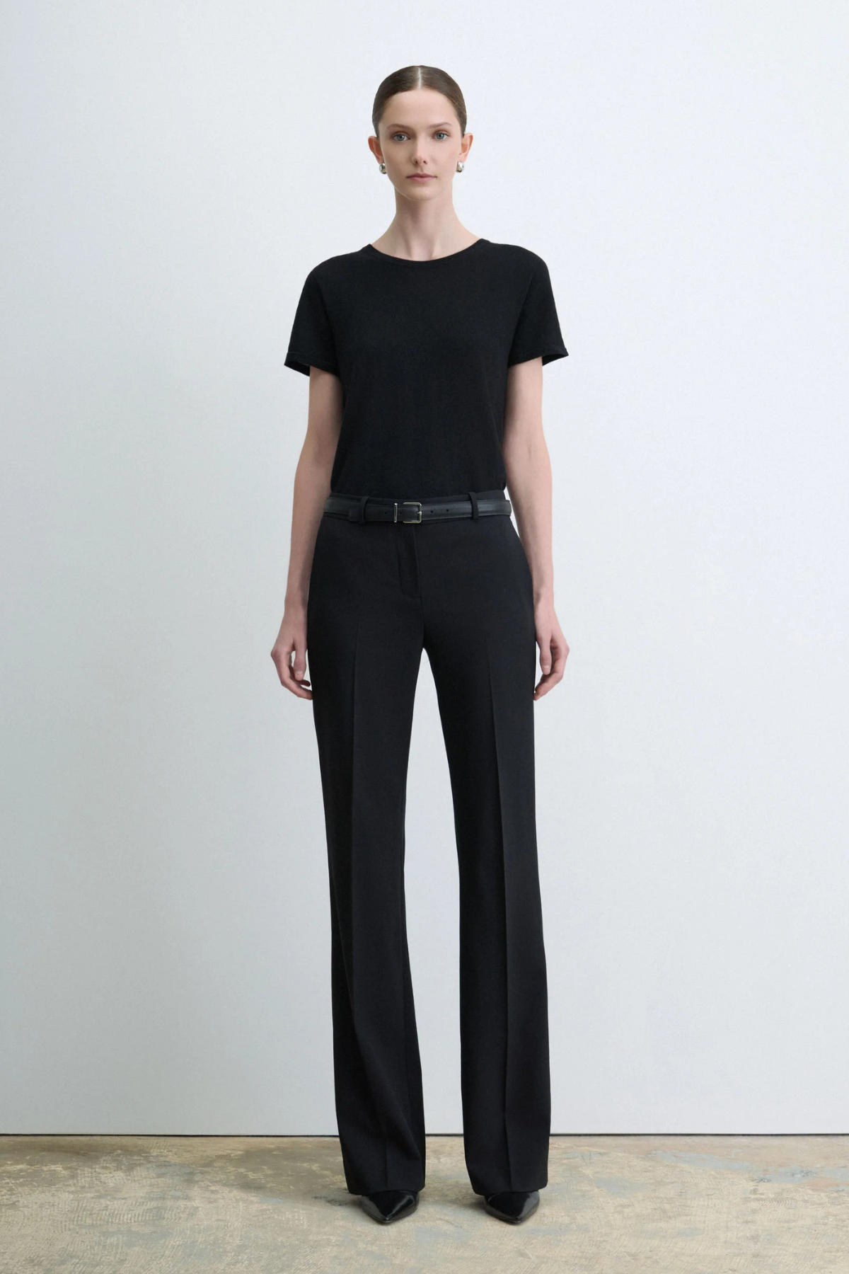 Judith & Charles Ilan B Pant in black stretch virgin wool, featuring a low-rise waist, pressed front creases, slash pockets and a flared leg.
